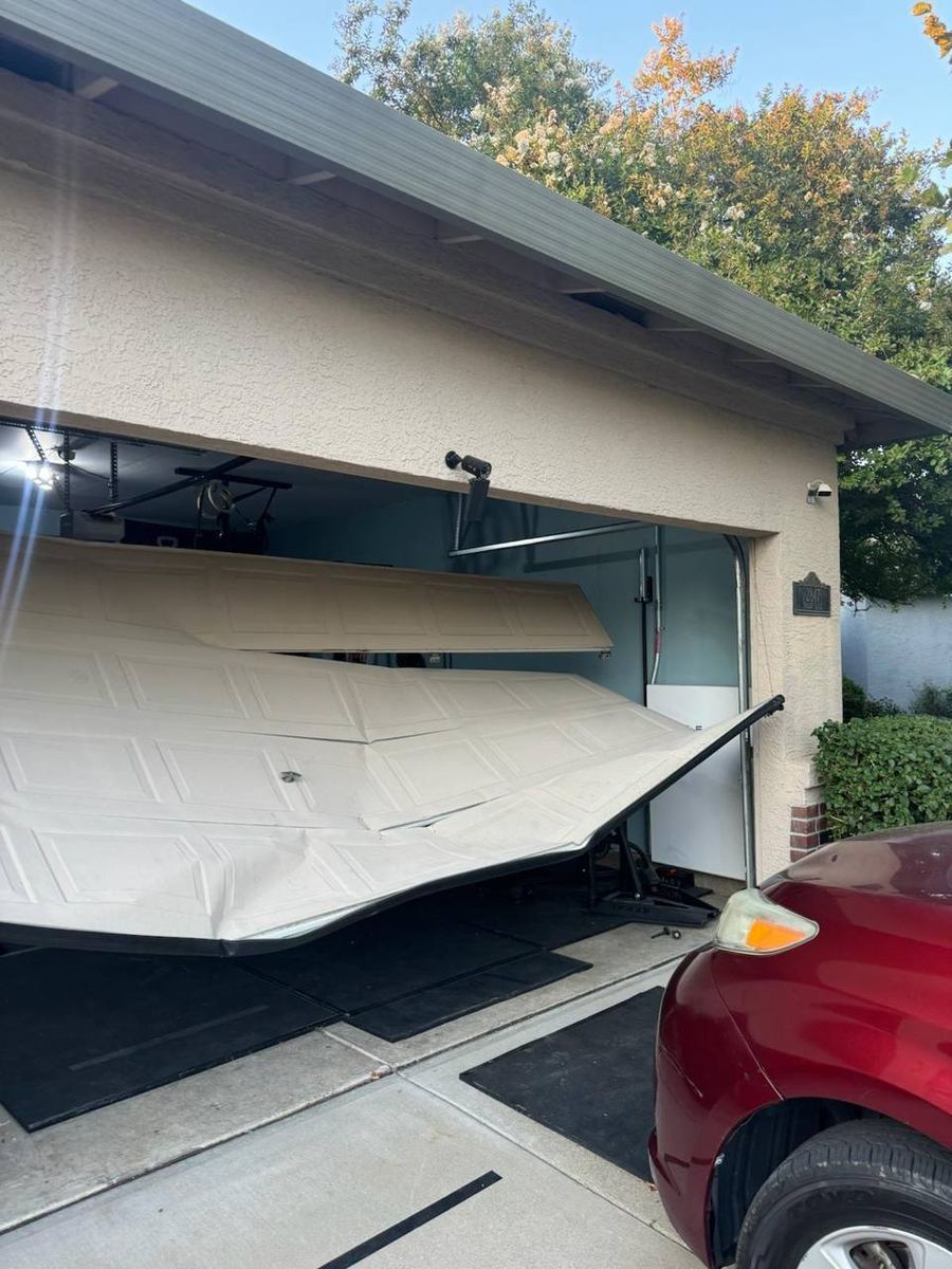Bent garage door panel before repair assessment